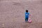 Young boy trying to ride a scooter in the gravel