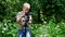 Young boy with video camera make movies about nature of green park background.