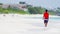 Young boy walking on tropical white sand beach