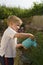 Young boy watering garden.