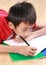 Young boy writing something on the book