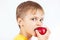 Young boy in a yellow shirt eating ripe red apple