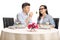 Young boyfriend giving a salad to his girlfriend at a restaurant table