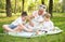 Young boys and grandmother sitting in sunny summer park.