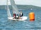 Young boys sailing racing small sailboat, rounding an orange marker. Commercial image