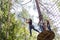 Young brave woman climbing in a adventure rope park