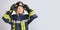 young brave woman in uniform of firefighter puts hardhat on her head
