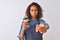 Young brazilian barista woman drinking take away coffee over isolated grey background pointing with finger to the camera and to