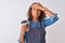 Young brazilian barista woman drinking take away coffee over isolated grey background stressed with hand on head, shocked with