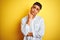 Young brazilian businessman wearing elegant shirt standing over isolated yellow background with hand on chin thinking about