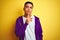 Young brazilian man wearing purple sweatshirt standing over isolated yellow background Thinking concentrated about doubt with