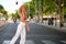 Young Brazilian woman speaking on the smartphone walking on zebra crossing.