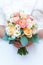 Young bride in a beautiful dress holding a bouquet in hands