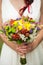 Young bride with bouquet of flowers in her hands