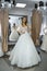 Young bride in charming wedding dress in boutique