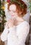 Young bride in a green wreath praying for happyness