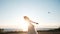 Young bride jumping on the beach at sea in summer. European woman in wedding dress jumps up at sunset, slow motion