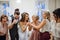 A young bride with other guests dancing and singing on a wedding reception.