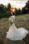 Young bride outside on a summer meadow at the sunset