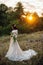 Young bride outside on a summer meadow at the sunset