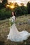 Young bride outside on a summer meadow at the sunset