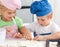 Young brother and sister kneading a dough