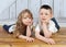 Young brother and sister laying together in floor