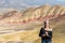 A young brown tourist with gray tufts walks through Painted Hills