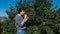 Young brunet man eats raspberries, tearing it from the bushes in the country.