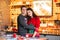 Young brunette asian woman and white man in Christmas sweaters making cookies together on the kitchen. Lights background