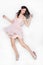 Young brunette beautiful woman dancing in pink dress isolated over white background