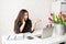 Young brunette business woman florist talking on the phone and laughing, working at the office