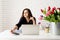 Young brunette business woman florist using laptop in the office, calculating costs