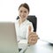 Young brunette business woman thumb up desk