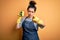 Young brunette cleaner woman wearing housekeeping gloves holding scourer scrub pointing with finger to the camera and to you, hand