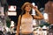Young brunette female solo traveler walking on city street in evening night in summer clothes.