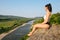 Young brunette girl with muscular body relaxing outdoor in beautiful mountains landscape. Meditation and Relax.