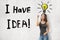 Young brunette girl wearing casual jeans and t-shirt pointing finger up with I HAVE IDEA sign and cartoon light bulb