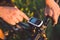 A young brunette guy on a mountain bike uses a cycling computer, a navigator in the field sunset of the day