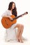 Young brunette lady playing acoustic guitar