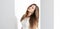 Young brunette with long wavy hairstyle in white interior, hair care and luxury beauty