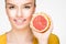 Young brunette with red grapefruit in her hand