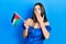 Young brunette teenager holding palestine flag covering mouth with hand, shocked and afraid for mistake