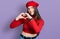 Young brunette teenager wearing french look with beret smiling in love doing heart symbol shape with hands