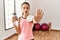 Young brunette teenager wearing sportswear holding water bottle doing stop gesture with hands palms, angry and frustration