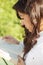 Young brunette in white reading book sideview