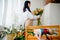 a young brunette woman in an apron in the process of creating a bouquet in the rustic style in her flower shop