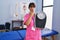 Young brunette woman as nutritionist holding weighing machine covering mouth with hand, shocked and afraid for mistake