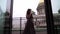 Young brunette woman in black luxury dress staying at balcony in a city
