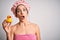 Young brunette woman with blue eyes wearing bath towel and shower cap holding duck toy scared in shock with a surprise face,